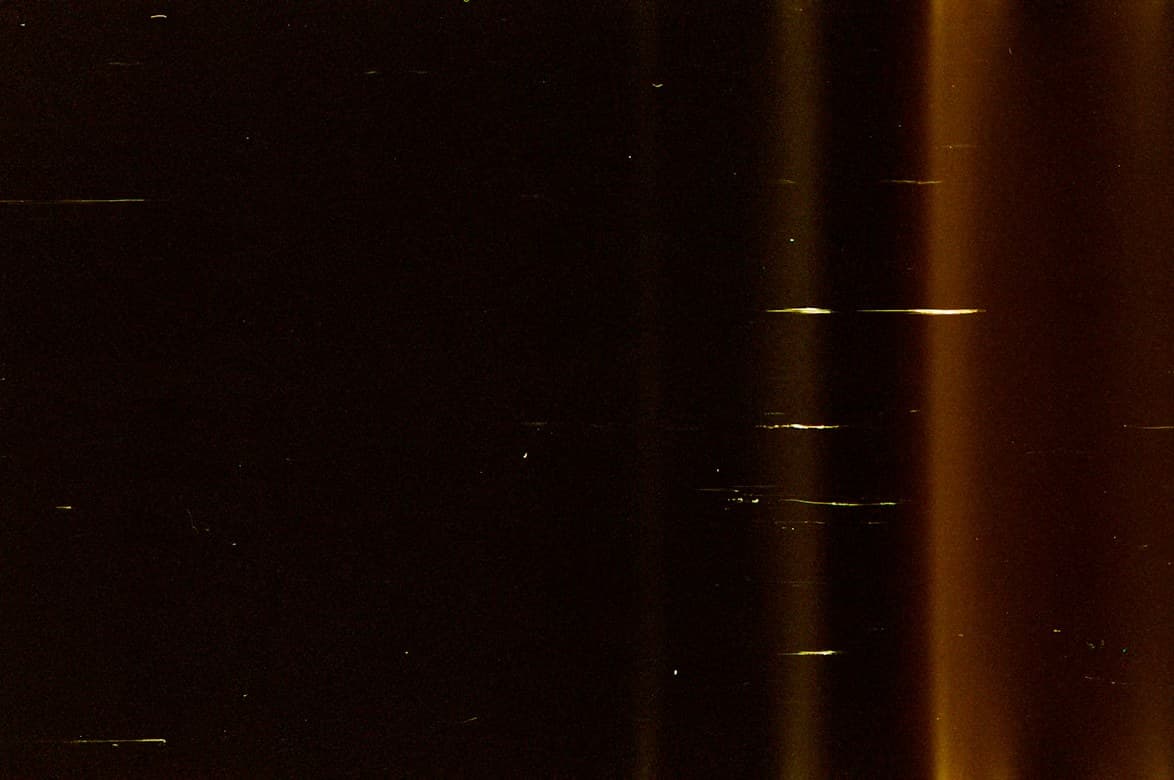 Fine streaks of amber light across a dark field, like data in motion